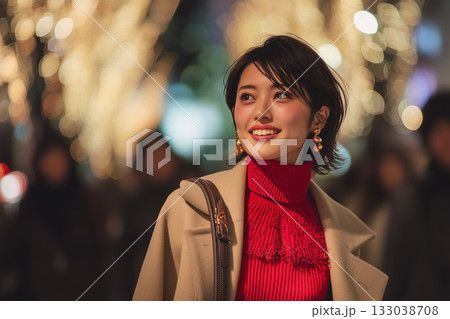 イルミネーション輝く夜の街で微笑む女性｜冬の華やぎと洗練をまとうホリデースナップ 133038708