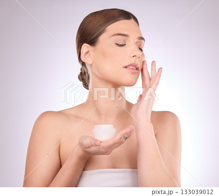 Beauty, skincare or woman with face cream product in daily grooming treatment with makeup cosmetics in studio. Dermatology, mockup space background or girl model applying facial sunscreen lotion 133039012
