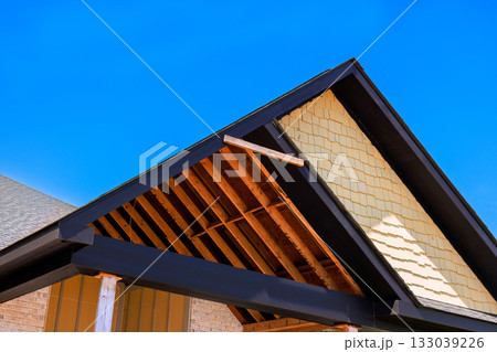 Construction work on anew roof with exposed framework under build new house Construction work on anew roof with exposed framework under build new house 133039226