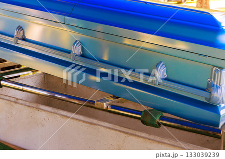 Blue coffin displayed at memorial service in tranquil outdoor setting under funeral ceremony 133039239
