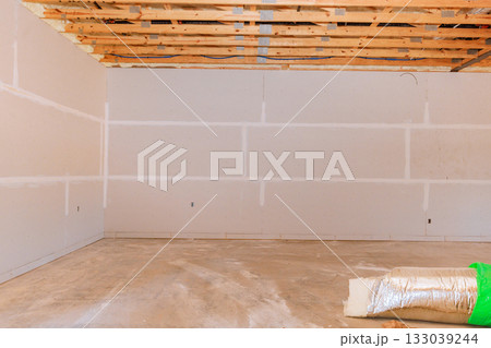 Interior construction site showing unfinished walls, exposed ceiling, construction materials  133039244