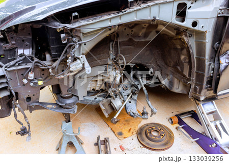 Car parked in driveway with open hood exposing engine components during maintenance Car parked in driveway with open hood exposing engine components during maintenance 133039256