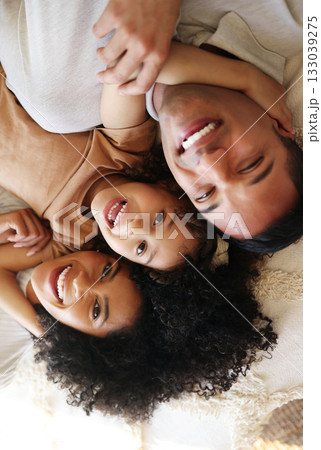 Bed, top view and father, mother and girl smile for bonding, quality time and affection in morning. Big family, happy and portrait of parents with happy child in bedroom relaxing together at home Bed, top view and father, mother and girl smile for bonding, quality time and affection in morning. Big family, happy and portrait of parents with happy child in bedroom relaxing together at home 133039275