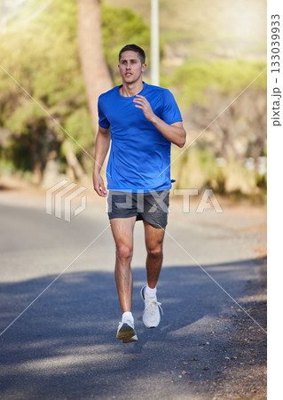 Fitness, running exercise and man on road for health, wellness and strength outdoors. Sports, training and young male athlete or runner workout, cardio jog or exercising for endurance and energy. 133039933