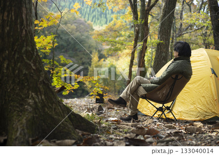 秋のソロキャンプ を楽しむ男性 133040014