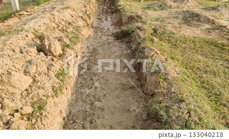 Trench dug in ground for laying underground water pipeline 133040218