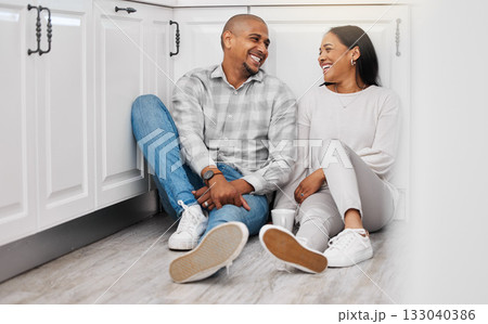 Love, happy and couple relax on a floor, talking and bonding in their home kitchen with coffee. Marriage, tea and man sitting with woman, laughing and enjoying conversation and relationship indoors Love, happy and couple relax on a floor, talking and bonding in their home kitchen with coffee. Marriage, tea and man sitting with woman, laughing and enjoying conversation and relationship indoors 133040386