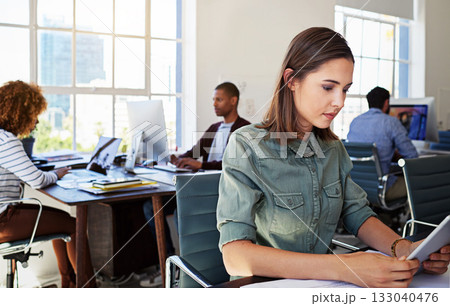 Woman, reading tablet and focus in office at web design startup with ideas, planning and job schedule. Tech vision, gen z developer and coworking for app ux, website and mobile touchscreen at desk 133040476