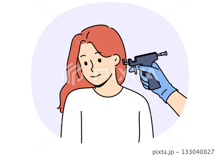Machine for piercing ears near woman visiting cosmetologist to get opportunity to wear earrings Machine for piercing ears near woman visiting cosmetologist to get opportunity to wear earrings 133040827