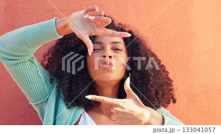 Frame, hands and portrait of woman with kiss on wall mockup for photography, moment or shape on orange background. Emoji, face and female photographer with shooting, perspective or finger border 133041057