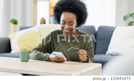 Happy black woman, credit card and phone for online shopping, fintech fees and ecommerce account payment at home. Mobile banking, financial budget and password for sales, savings and membership code Happy black woman, credit card and phone for online shopping, fintech fees and ecommerce account payment at home. Mobile banking, financial budget and password for sales, savings and membership code 133041075