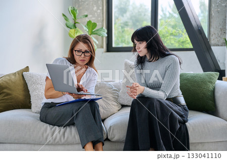 Young female patient in therapy session talking with female psychologist Young female patient in therapy session talking with female psychologist 133041110