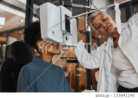 Eye exam, vision and woman patient in optometry clinic for testing, eyesight and optical assessment. Healthcare, optometrist consultation and doctor use medical equipment, phoropter and lens for eyes 133041140