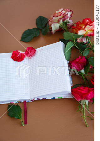 Notes over a cup of cappuccino among fresh rose petals 133041177