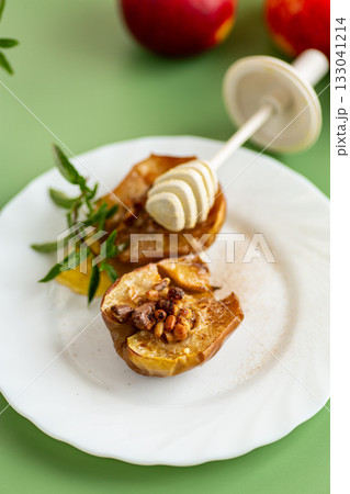 A cozy homemade dessert of baked apples with golden honey A cozy homemade dessert of baked apples with golden honey 133041214