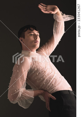 Gen z fashion, creative pose and vintage aesthetic with retro clothing in studio. Isolated, black background and lgbtq or gay model with woman clothes and creativity for non binary and beauty art Gen z fashion, creative pose and vintage aesthetic with retro clothing in studio. Isolated, black background and lgbtq or gay model with woman clothes and creativity for non binary and beauty art 133041267
