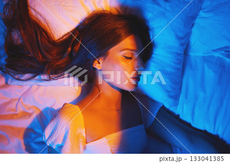 Sleeping beauty, lights and woman with sleep and creative neon lighting. Resting, face and model glow and feeling relax and calm on a bed pillow with aesthetic profile in a bedroom bed at home Sleeping beauty, lights and woman with sleep and creative neon lighting. Resting, face and model glow and feeling relax and calm on a bed pillow with aesthetic profile in a bedroom bed at home 133041385