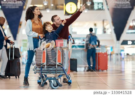 Pointing, travel and interracial family at the airport looking at a departure time for a flight. Happy, trip and parents with a child to look at information for arrival or leaving of an airplane 133041528
