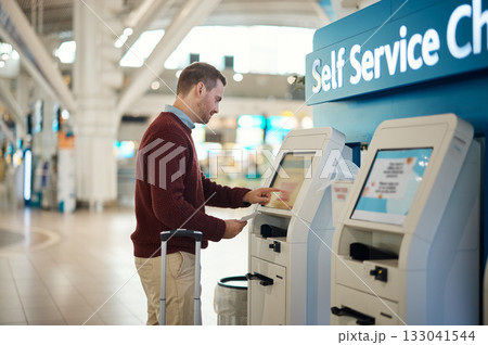 Man, airport and self service kiosk for check in, ticket registration or online boarding pass. Male traveler by terminal machine for travel application, document or booking flight with luggage 133041544