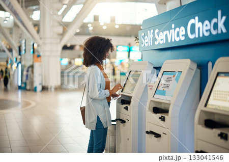 Black woman, airport and self service kiosk for check in, ticket registration or online boarding pass. African female traveler by terminal machine for travel application, document or booking flight Black woman, airport and self service kiosk for check in, ticket registration or online boarding pass. African female traveler by terminal machine for travel application, document or booking flight 133041546