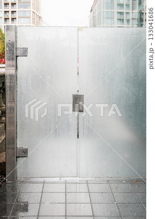 Modern frosted glass gate with raindrops and metal frame in urban city environment 133041686