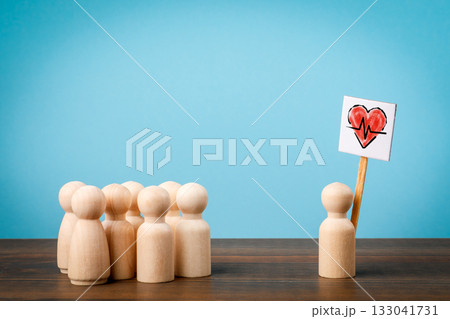 Wooden figures symbolizing healthcare support and medical care concept with one holding a red heart Wooden figures symbolizing healthcare support and medical care concept with one holding a red heart 133041731