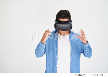 Man, vr and and futuristic technology on mockup standing amazed against a white studio background. Male in virtual reality or future innovation with digital headset on mock up space 133041916