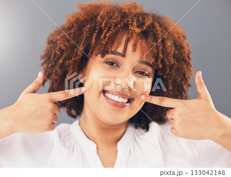 Portrait, point and teeth with black woman, smile or oral hygiene against grey studio background. Face, African American female or lady with gesture for mouth, happiness or dental health for wellness 133042148