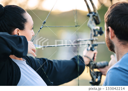 Archery, woman and target training with an instructor on a field for hobby, aim and control. Arrow, practice and archer people together outdoor for hunting, precision and weapon, shooting competition 133042214