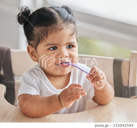 Baby, eating and girl with toddler food for nutrition and child growth in a kitchen at home. Youth, hungry and spoon of a kid in the morning on a children high chair in a house getting fed a meal Baby, eating and girl with toddler food for nutrition and child growth in a kitchen at home. Youth, hungry and spoon of a kid in the morning on a children high chair in a house getting fed a meal 133042595