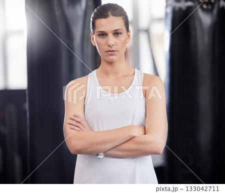 Portrait, fitness and boxing with a sports woman in a gym, standing arms crossed feeling serious or confident. Exercise, training and focus with a female boxer or athlete standing in a health studio 133042711