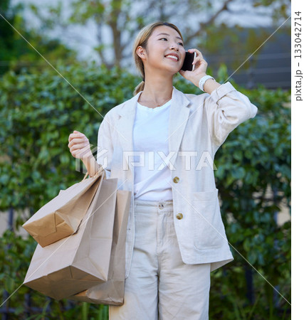 Phone call, Asian woman and shopping bags of a gen z person with mobile connection outdoor. Happy, communication and conversation after shop discount sale and promotion at a mall or luxury boutique Phone call, Asian woman and shopping bags of a gen z person with mobile connection outdoor. Happy, communication and conversation after shop discount sale and promotion at a mall or luxury boutique 133042714
