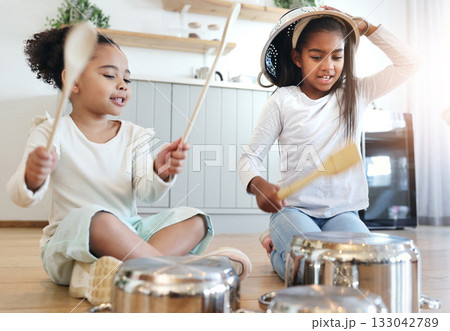 Girl children, kitchen and drums with pot in black family home, happiness and comic bonding on holiday. Young kids, sisters and happy for comedy music, joke and excited in morning for playful friends 133042789