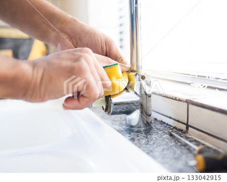 Plumber man, tap and hands of maintenance for sponge, home renovation and builder service. Closeup handyman, sink and plumbing installation in house, engineering contractor or upgrade pipeline system 133042915