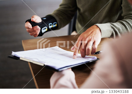 Injury, compensation and man hands with insurance documents, legal contract and paperwork. Disability, accident and people in lawyer or attorney meeting for advice, agreement or policy report closeup 133043188