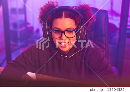 Video game, teenager girl and headphones in home for esports, online games and virtual player. Female gamer, computer live streaming and gaming with headset in neon lighting, tech and gen z streamer Video game, teenager girl and headphones in home for esports, online games and virtual player. Female gamer, computer live streaming and gaming with headset in neon lighting, tech and gen z streamer 133043224