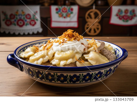 Traditional polish pierogi dumplings with sour cream and fried onion in a ceramic bowl Traditional polish pierogi dumplings with sour cream and fried onion in a ceramic bowl 133043709