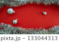 Christmas background with copy space. Christmas balls and tinsel on a red background. 133044313