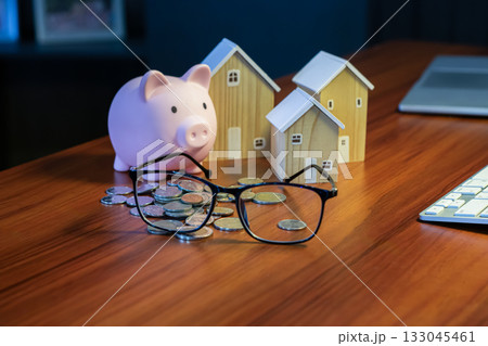 Pink piggy bank, wooden house and pile of coins, saving and investment concept. Pink piggy bank, wooden house and pile of coins, saving and investment concept. 133045461