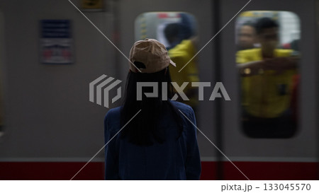 Blurred image of a woman standing on a train platform watching a train pass by. Blurred image of a woman standing on a train platform watching a train pass by. 133045570