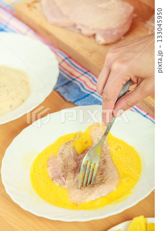Preparing meal of breaded chicken cutlets 133045950