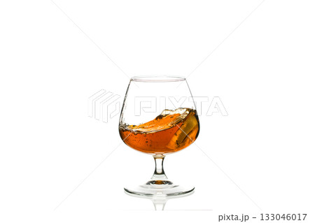 A glass of liquor is poured into a glass cup A glass of liquor is poured into a glass cup 133046017