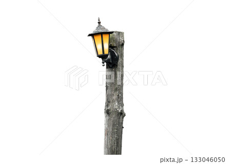A street light is lit up and is on a pole A street light is lit up and is on a pole 133046050