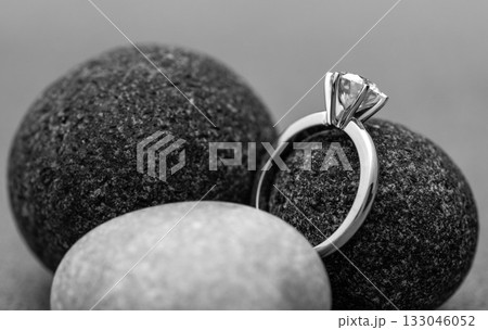 A diamond ring is placed on top of a rock 133046052