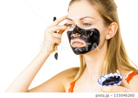 Woman being apply black mask to skin face 133046260