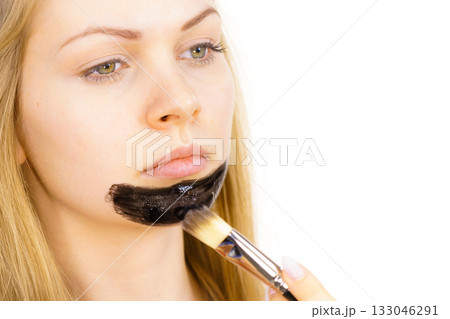 Girl being apply carbo mask to skin face 133046291