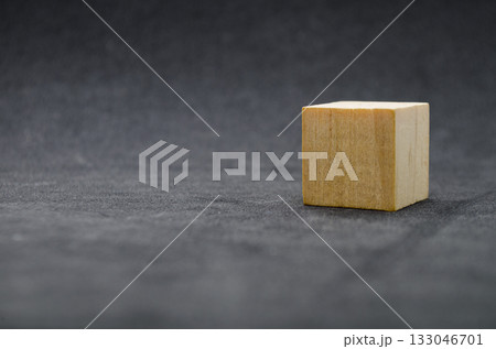 An isolated wooden cube on dark background with customizable space for text or ideas. Copy space concept An isolated wooden cube on dark background with customizable space for text or ideas. Copy space concept 133046701
