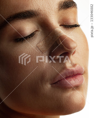 Woman resting peacefully with nose bandage after beauty correction recovery phase Woman resting peacefully with nose bandage after beauty correction recovery phase 133046882