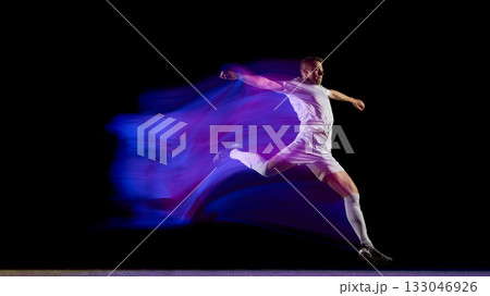 Football player midair kick captured with vibrant motion blur 133046926