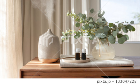 This cozy wellness space features a diffuser, essential oils, and fresh plants, perfect for stress relief and relaxation at home This cozy wellness space features a diffuser, essential oils, and fresh plants, perfect for stress relief and relaxation at home 133047228